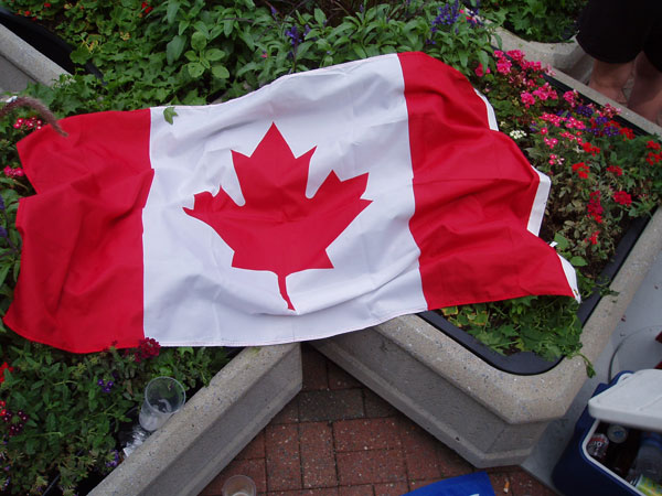 Canadian Flag in flower bed, next to cooler filled with beer!
